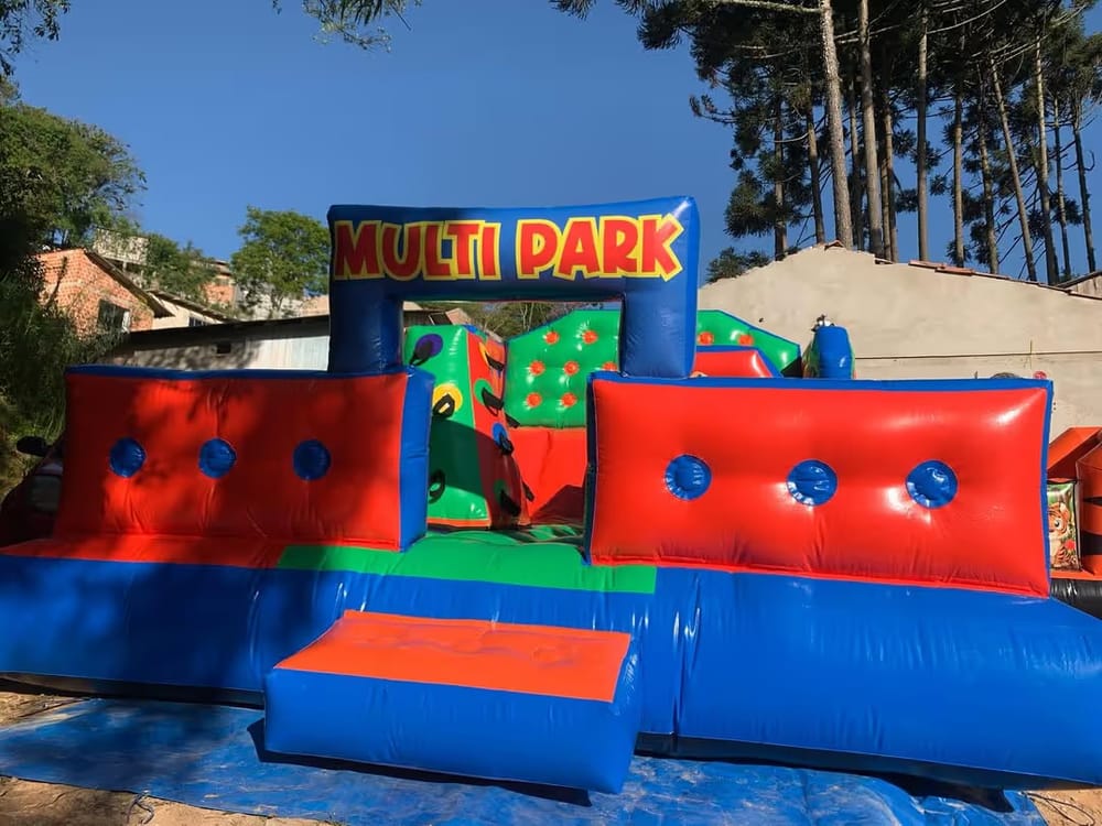 Inflável Multi Park com obstáculos coloridos montado em um gramado