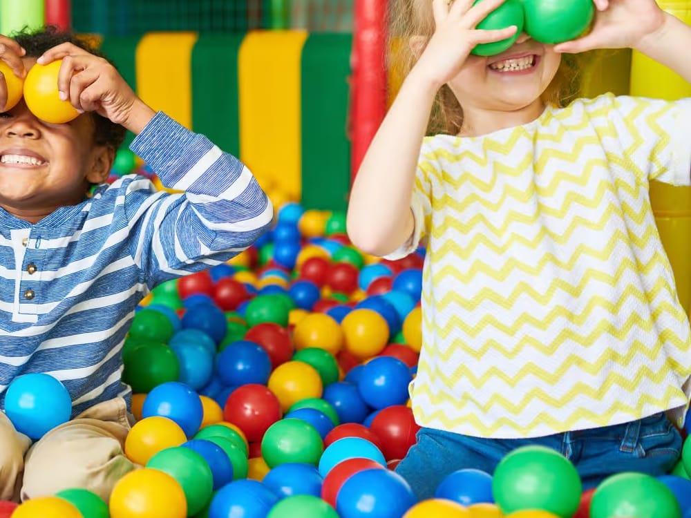 Crianças brincando em uma piscina de bolinhas coloridas
