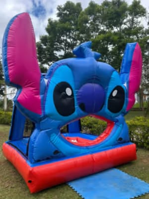 Inflável de personagem azul com orelhas grandes montado no jardim